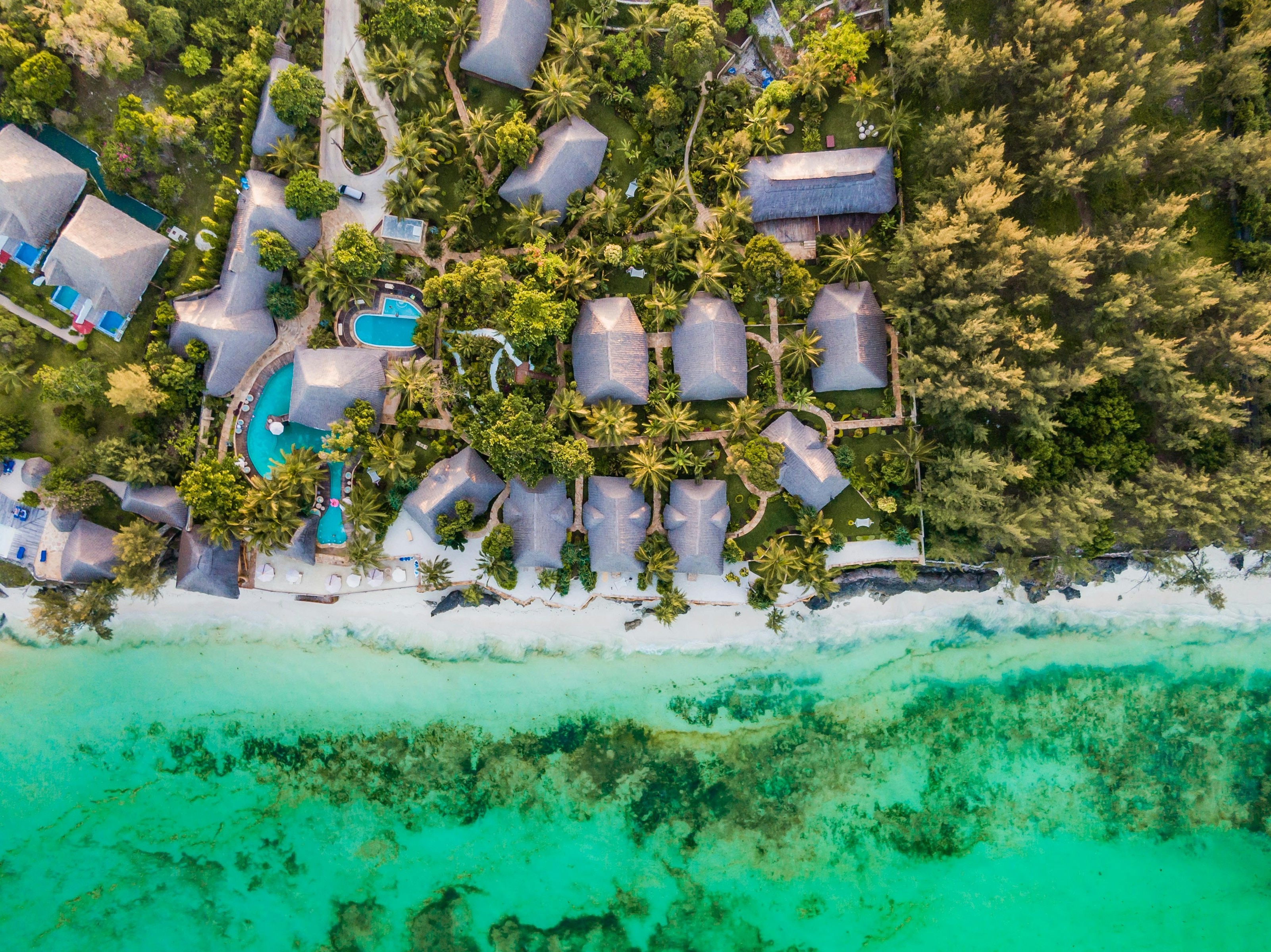 En top-down udsigt over en strand og jungle resort