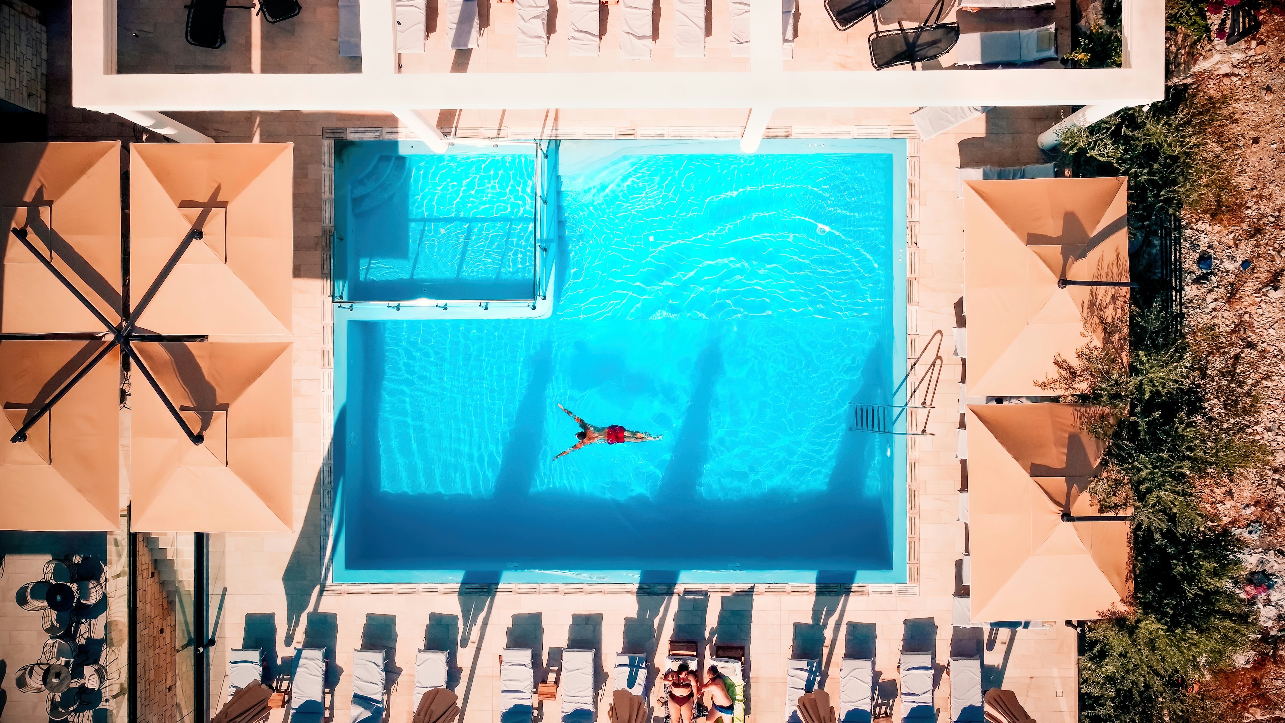 A view from above of a hotel with a pool and a man swimming