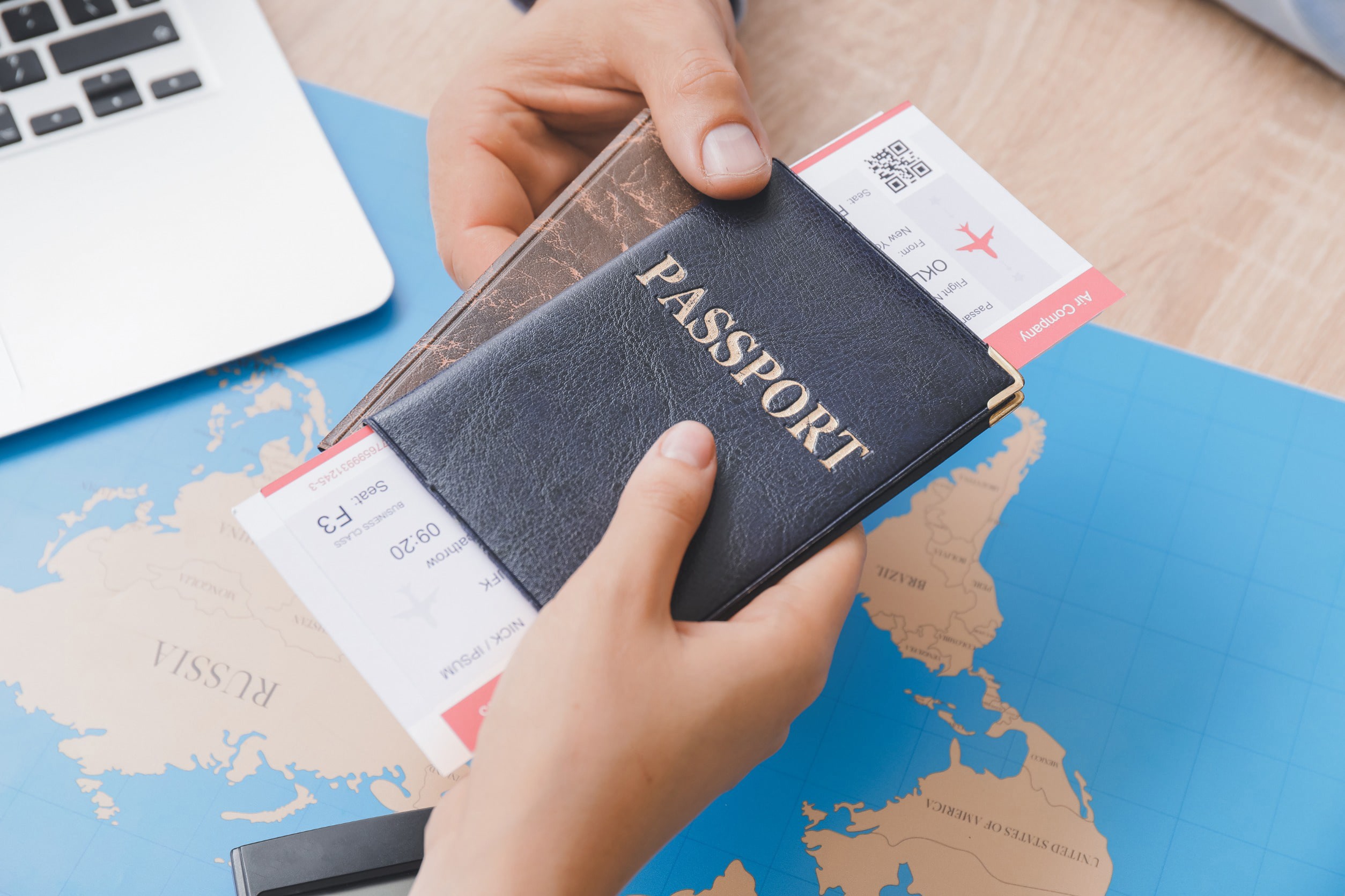 Two hands holding passport cases and flight tickets organized for a trip abroad