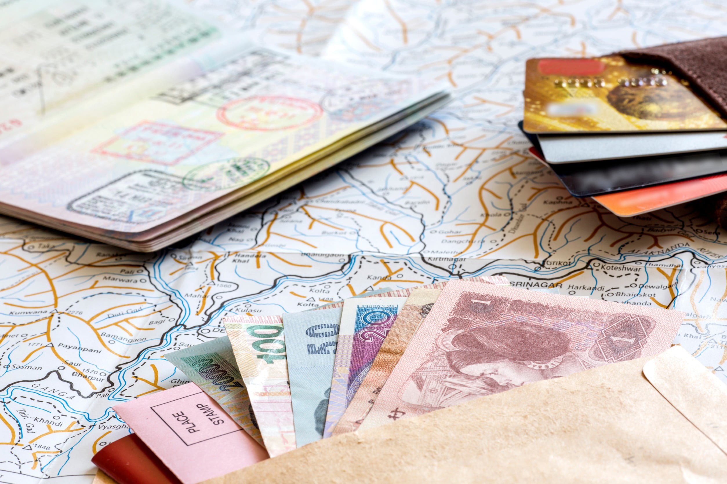 Travel currency in banknotes, credit cards and a passport is on a map before a trip