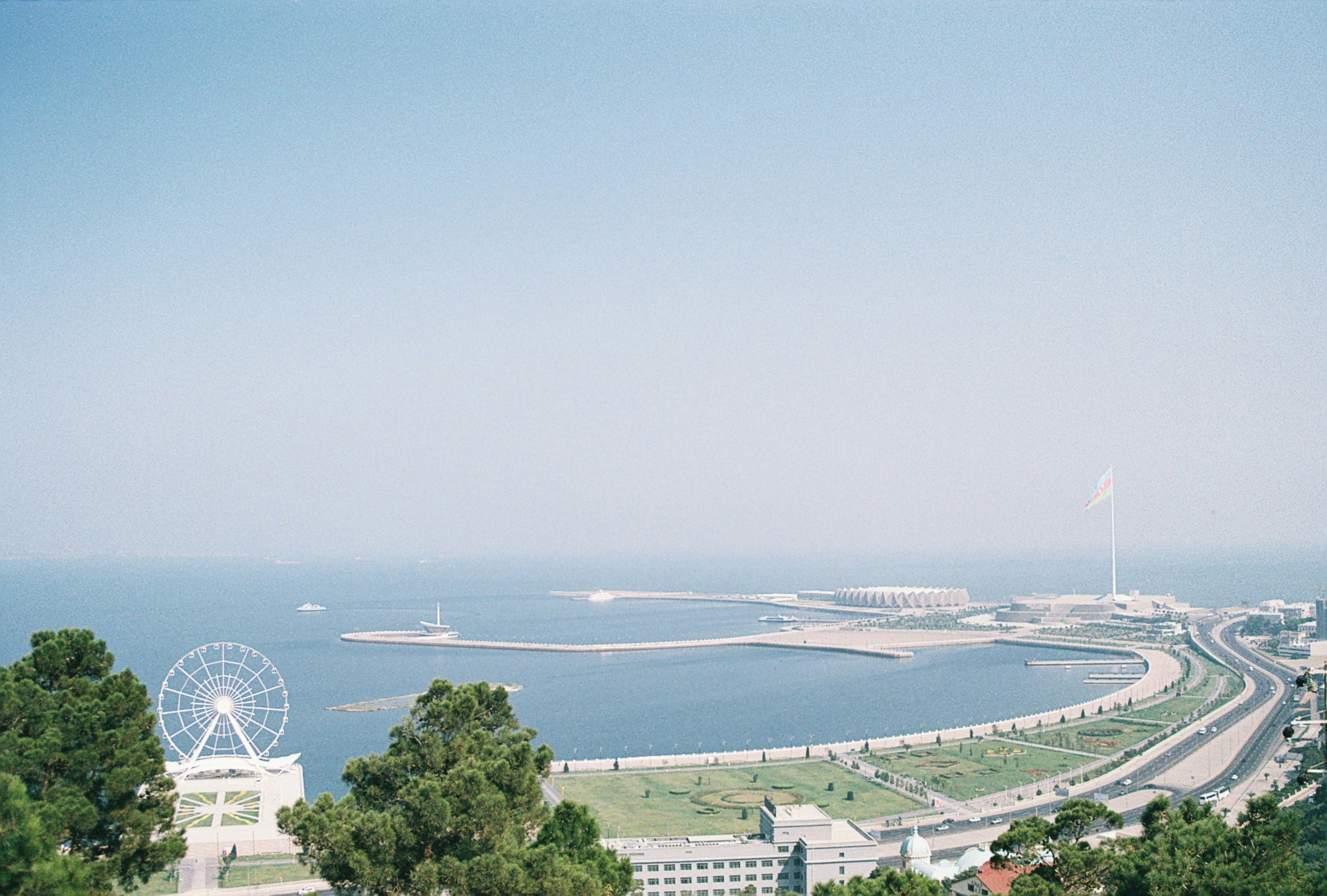 Kysthavn med strand i Baku møder blåt hav og tåget blå himmel i baggrunden