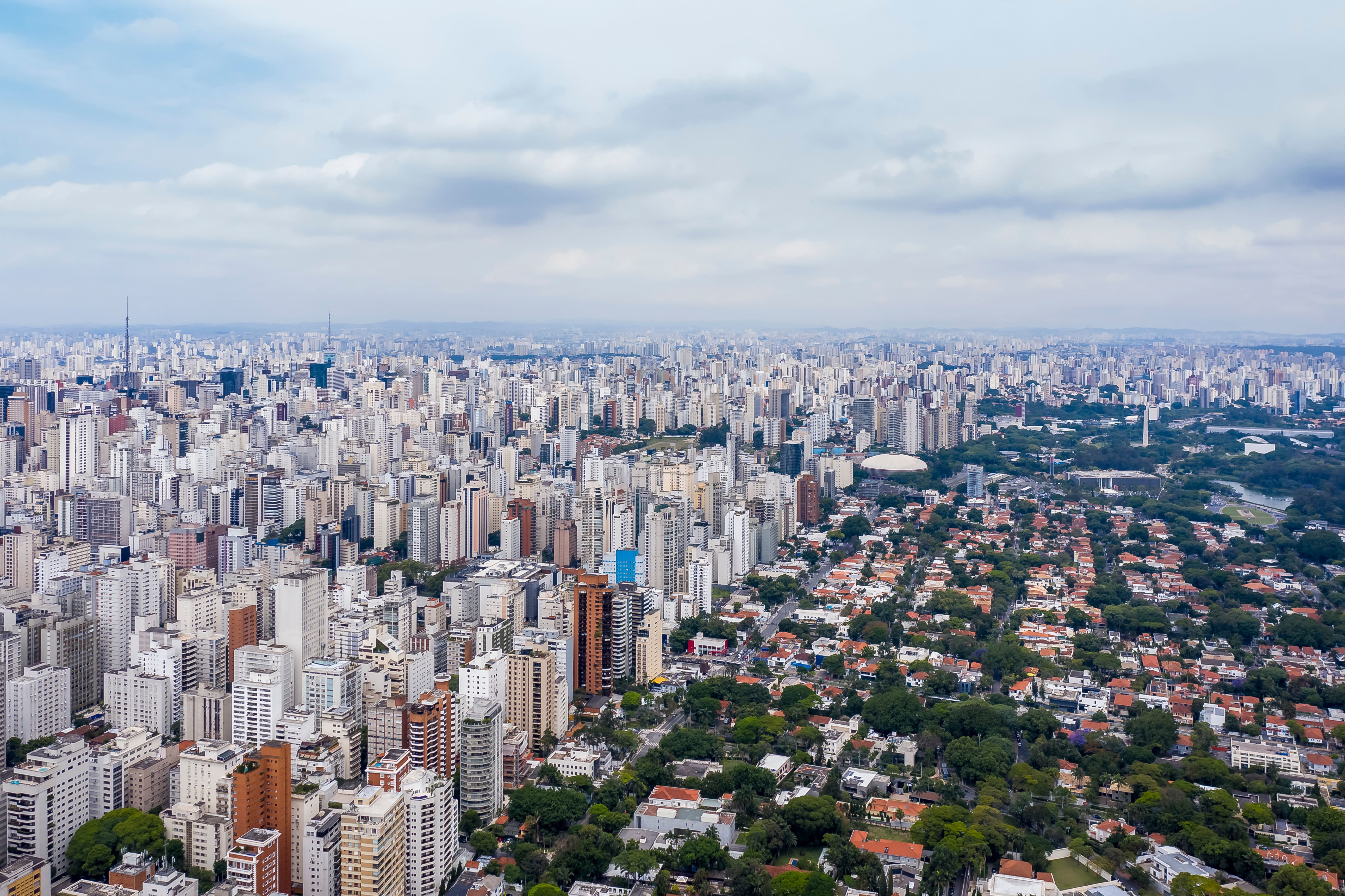 Panoramaudsigt over São Paulo by, bygninger møder masser af grønt og parker med en overskyet himmel