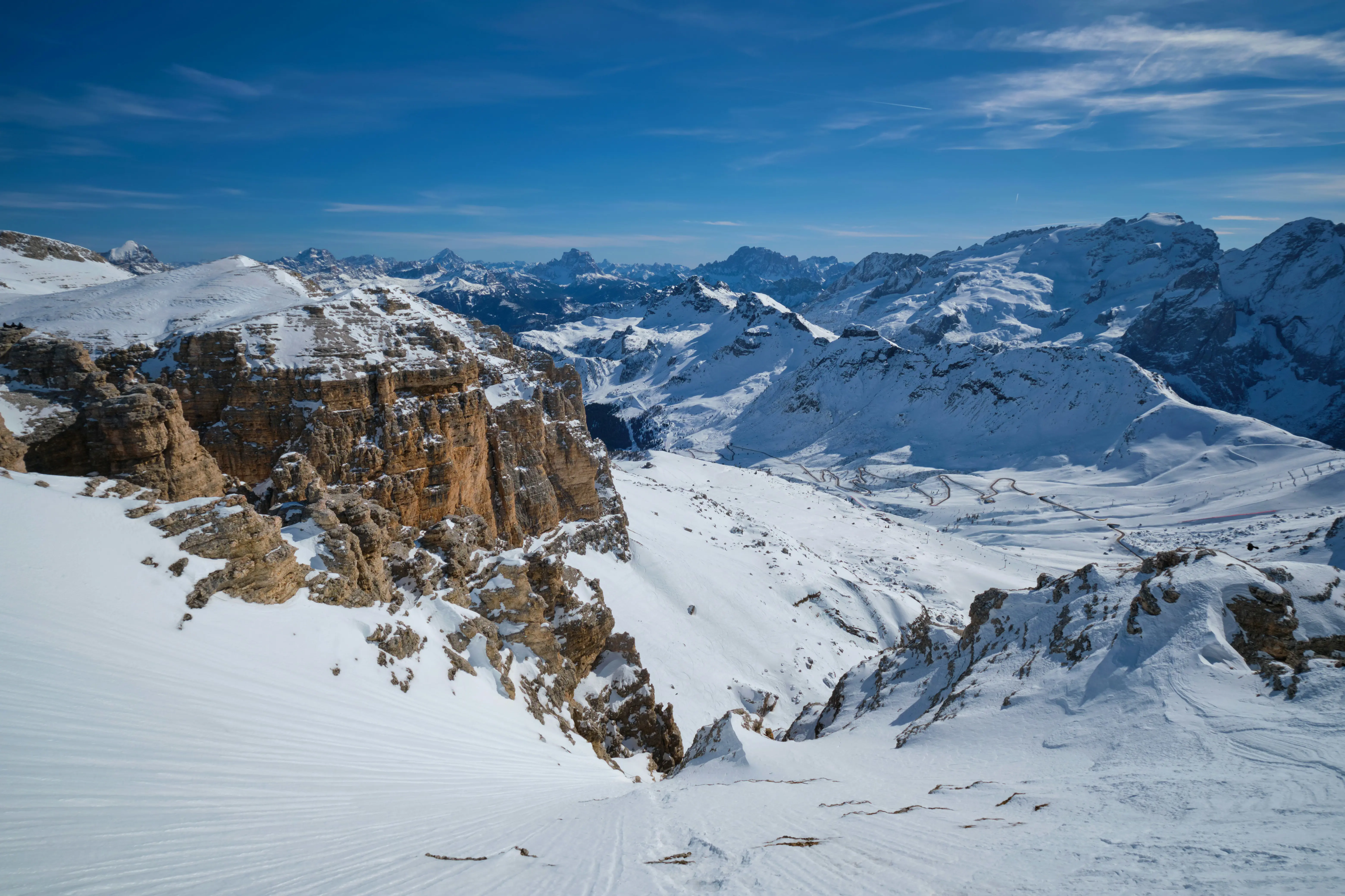 Travel to Canazei - View and view of the snow-capped Dolomites of Canazei with blue sky and mountain range in the background