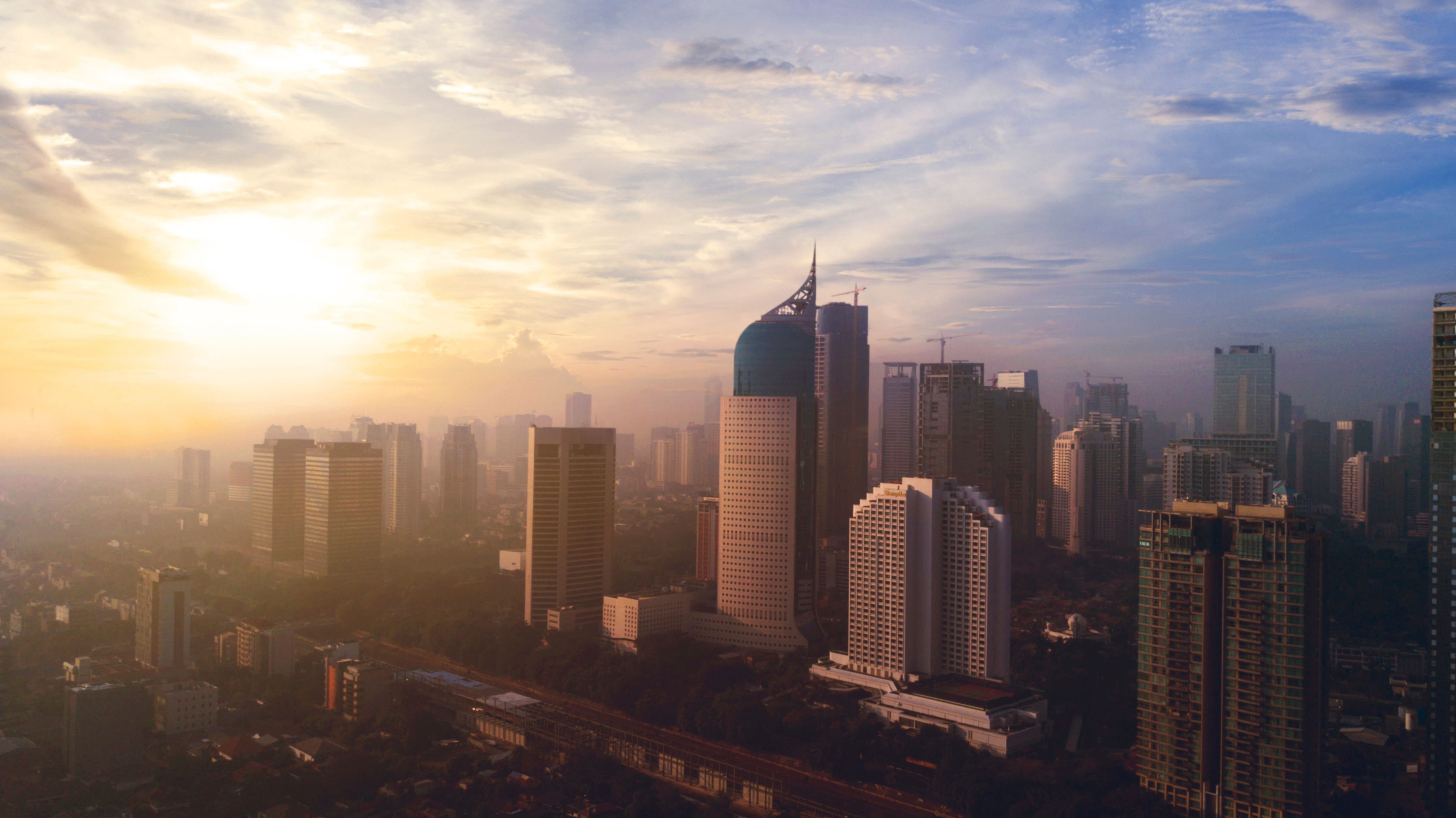 Rejs til Jakarta - Solopgang over Jakartas skyline, men skyskrabere møder en blå himmel