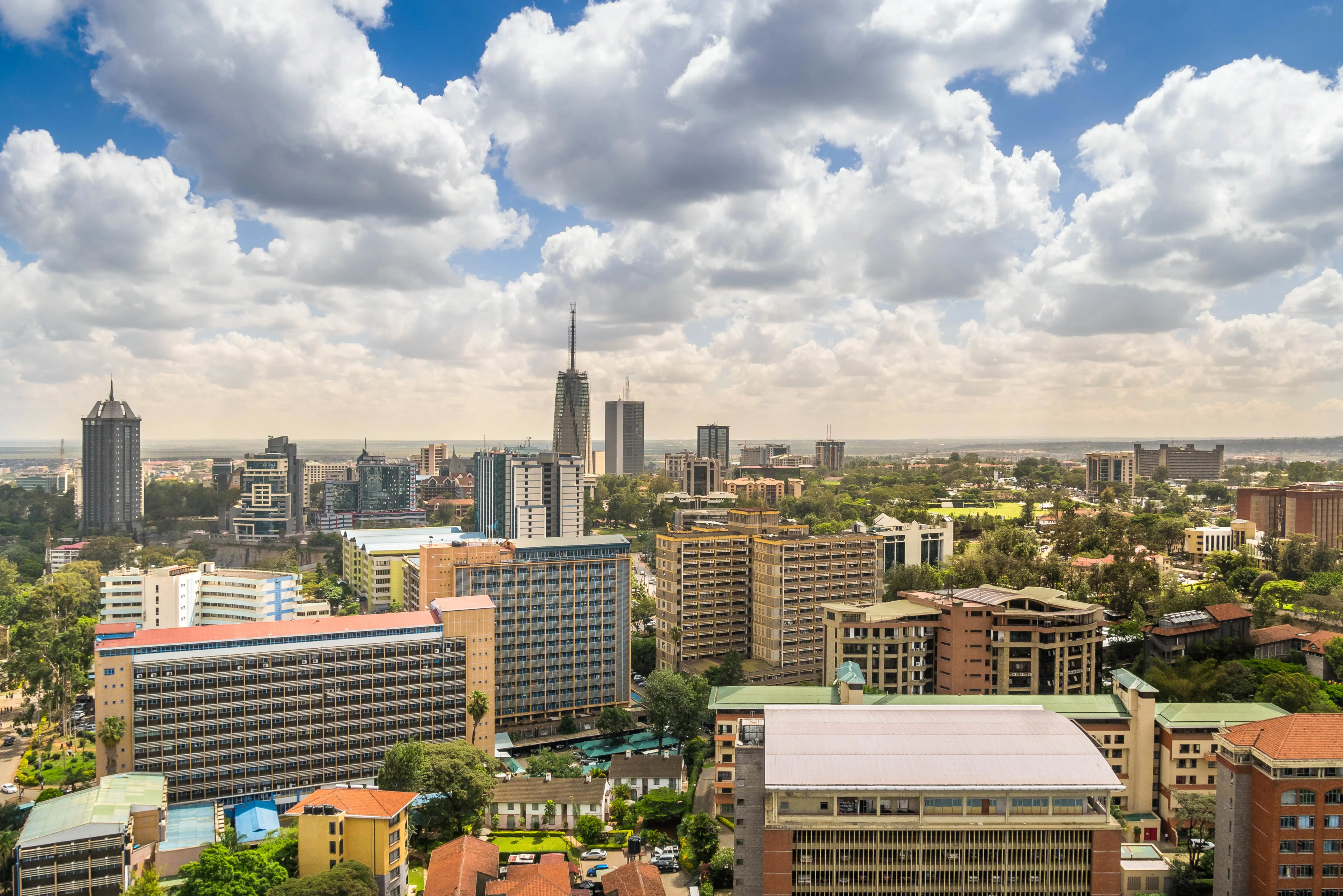 Rejs til Nairobi - Udsigt over Nairobi by med flere bygninger, skyskrabere og grønne områder rundt omkring, der møder en blå himmel