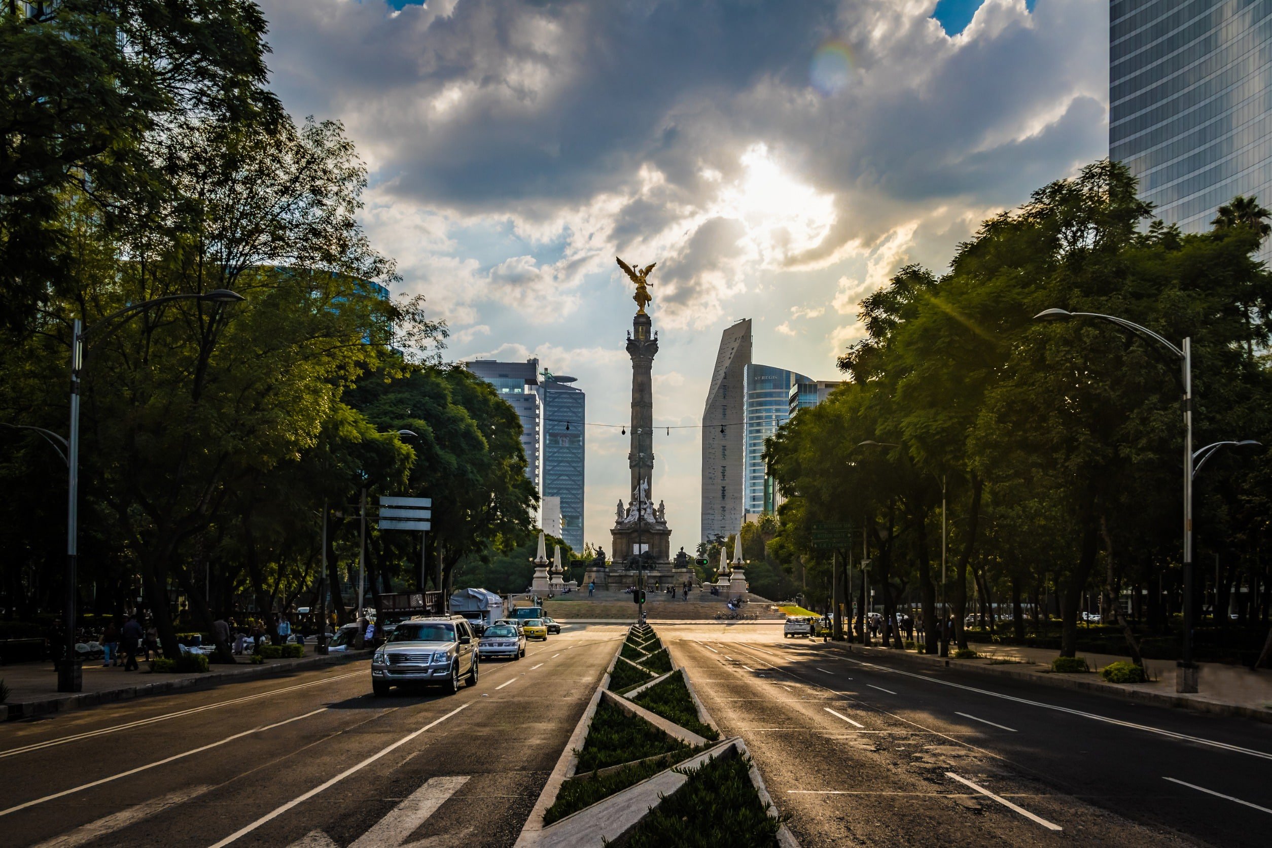 View from road leading up to a roundabout with a statue pointing like the sky in Mexico City