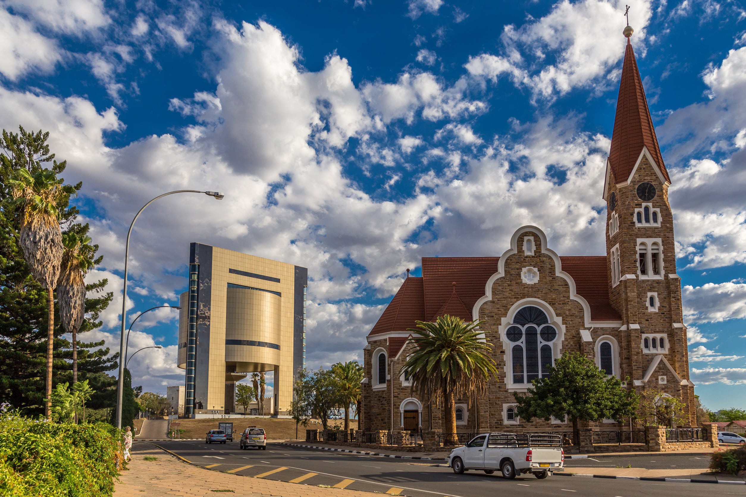 Smuk murstenskirke i Windhoek med grønne områder omkring den og blå himmel med skyer i baggrunden