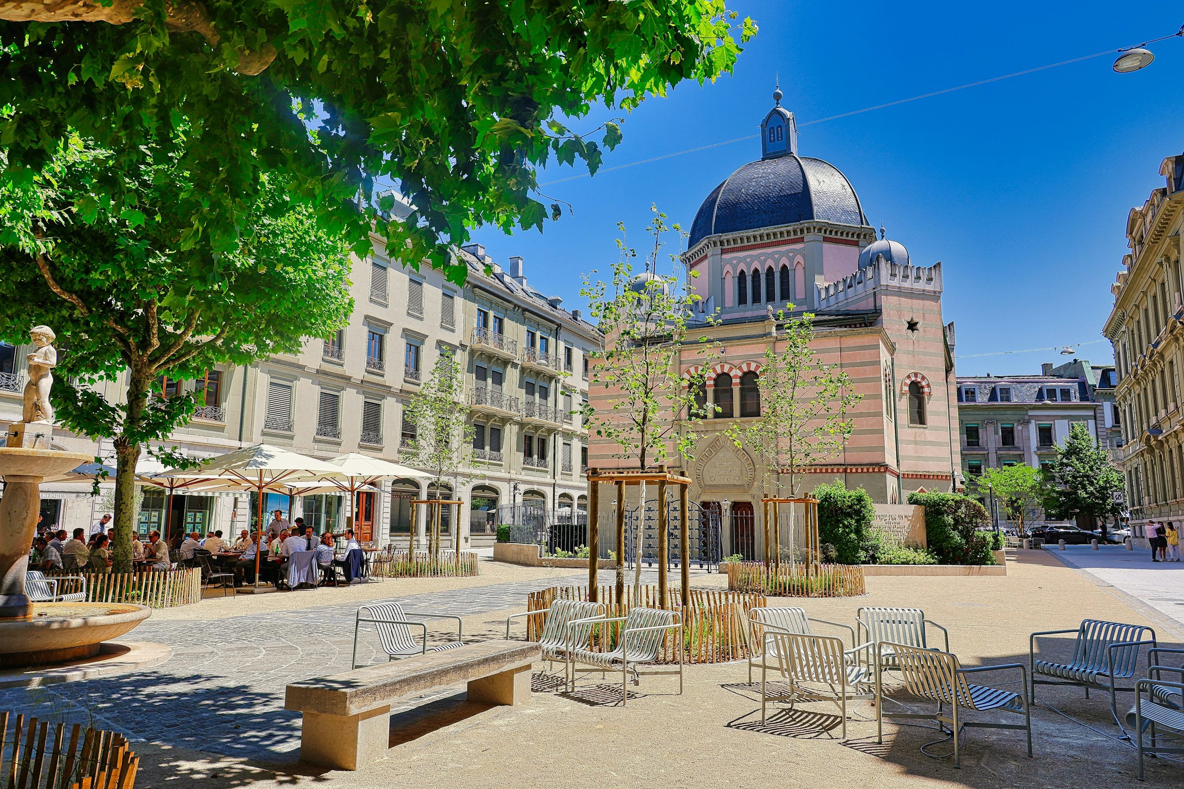 Et torv med udendørs siddepladser og smukke bygninger i centrum af Genève, Schweiz