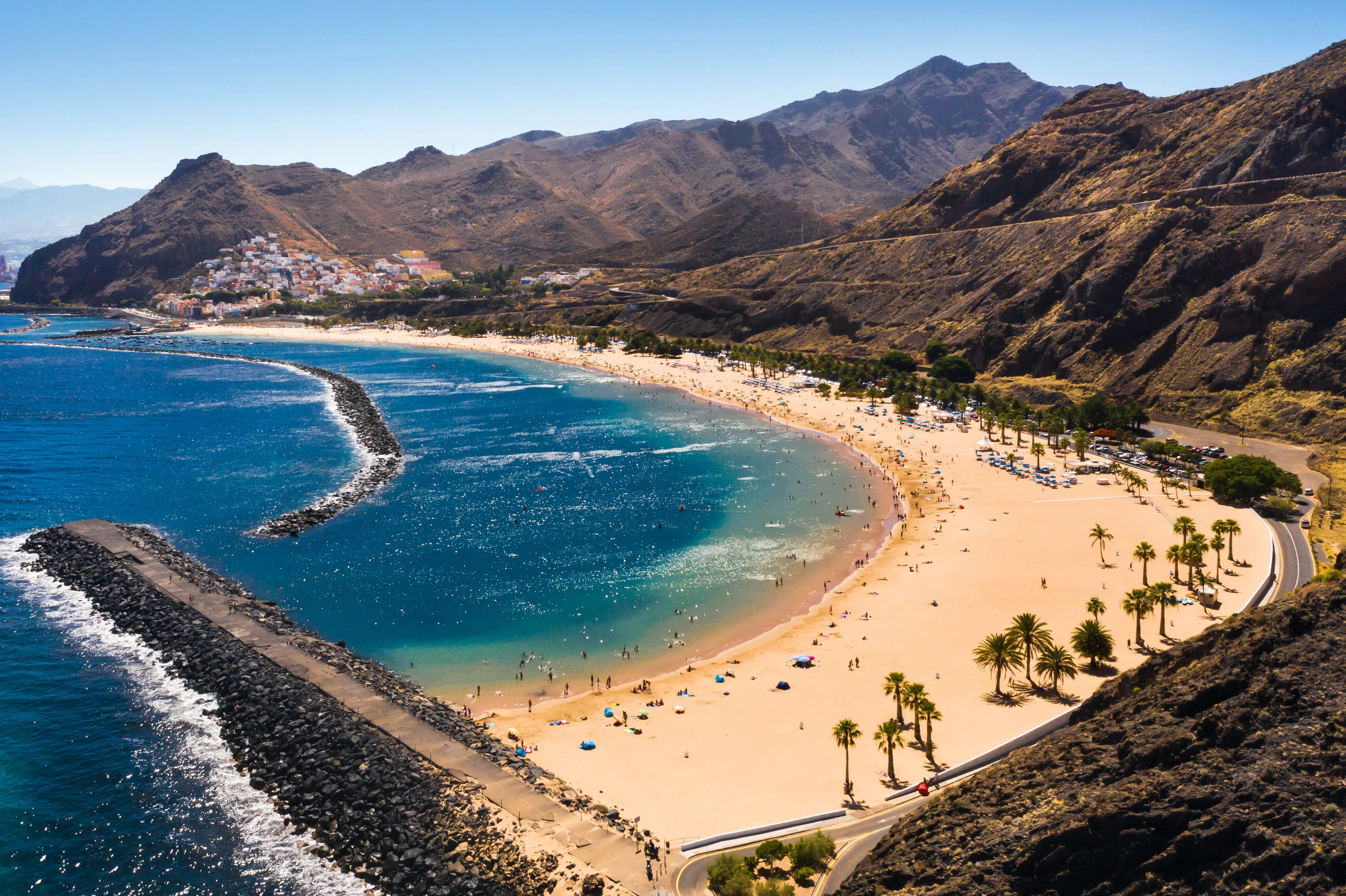 Blue sea beach surrounded by mountains and greenery