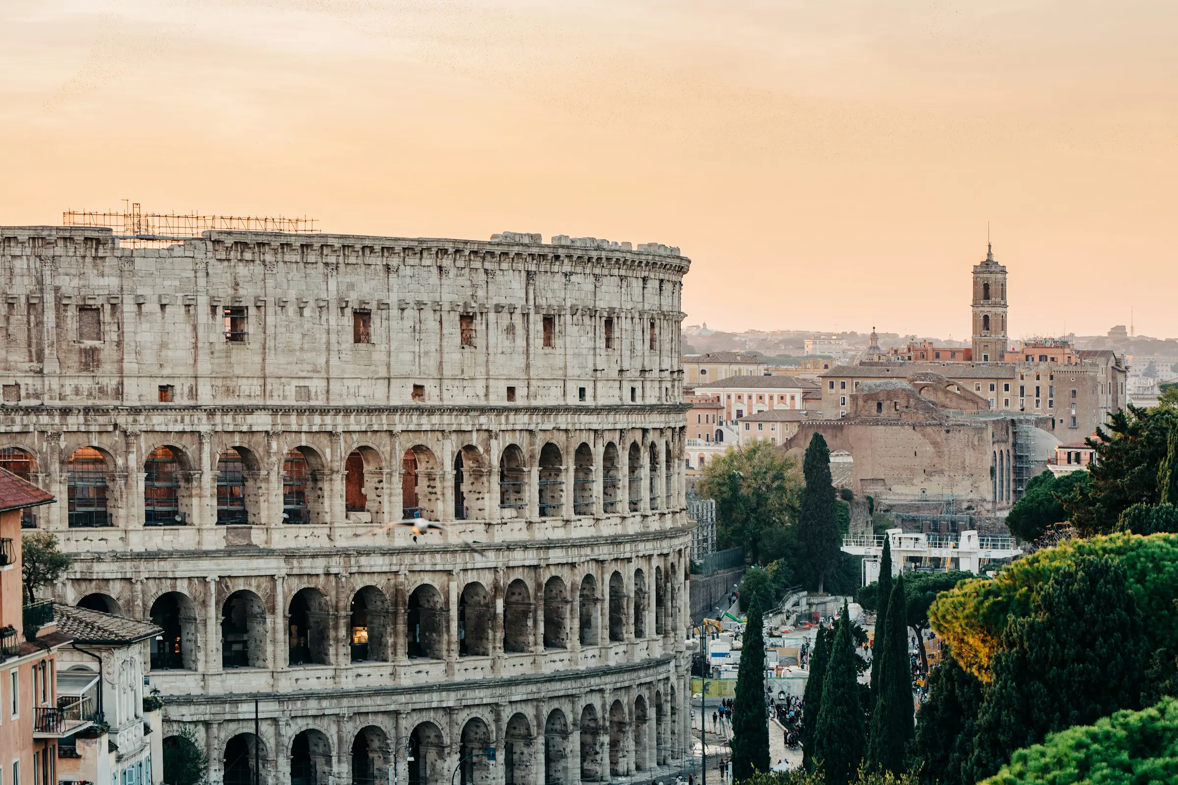 Solnedgang over Colosseum i Rom med grønne områder