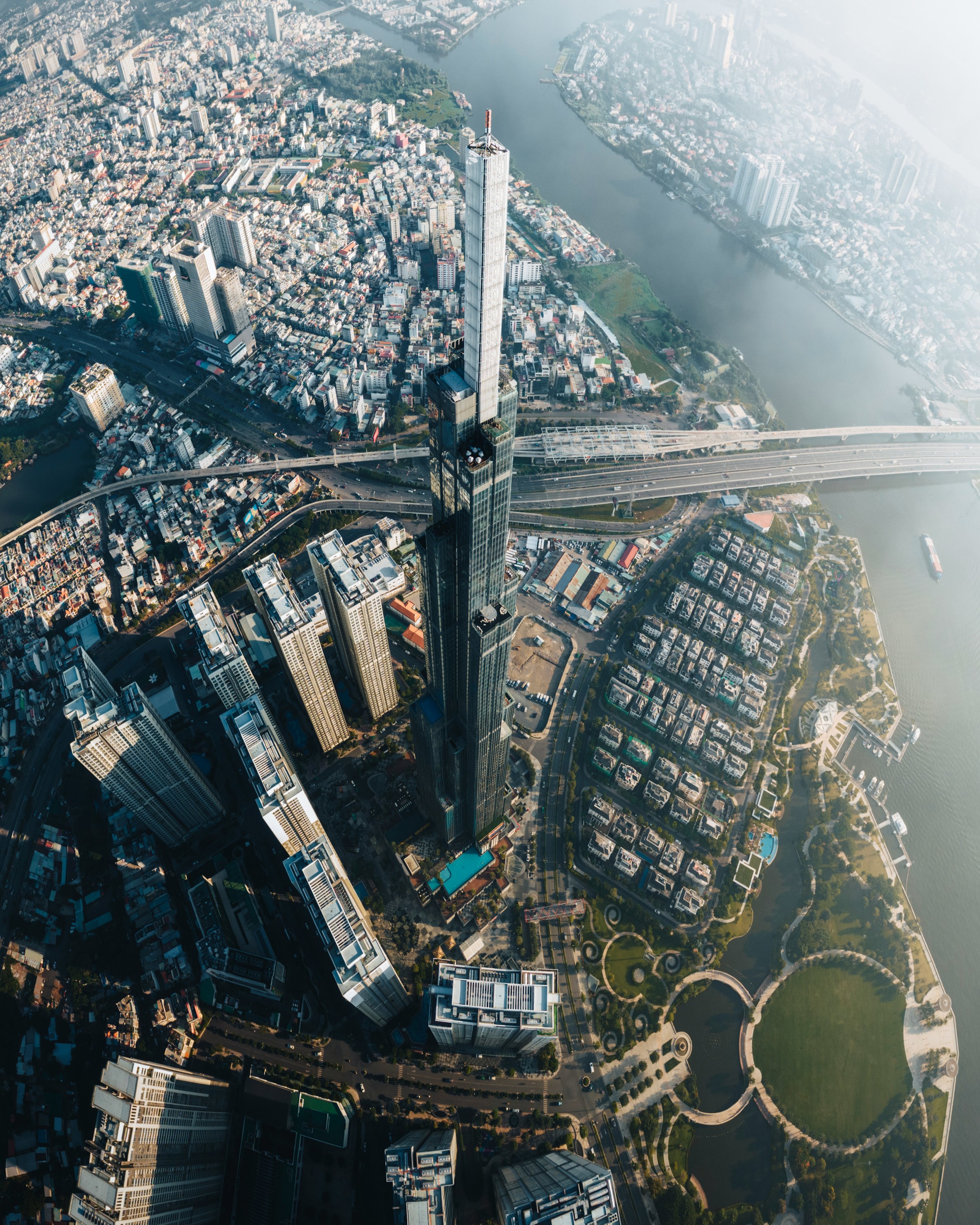 Luftfoto af Ho Chi Minh City ved vandet med høje skyskrabere og broer, i et bylandskab.